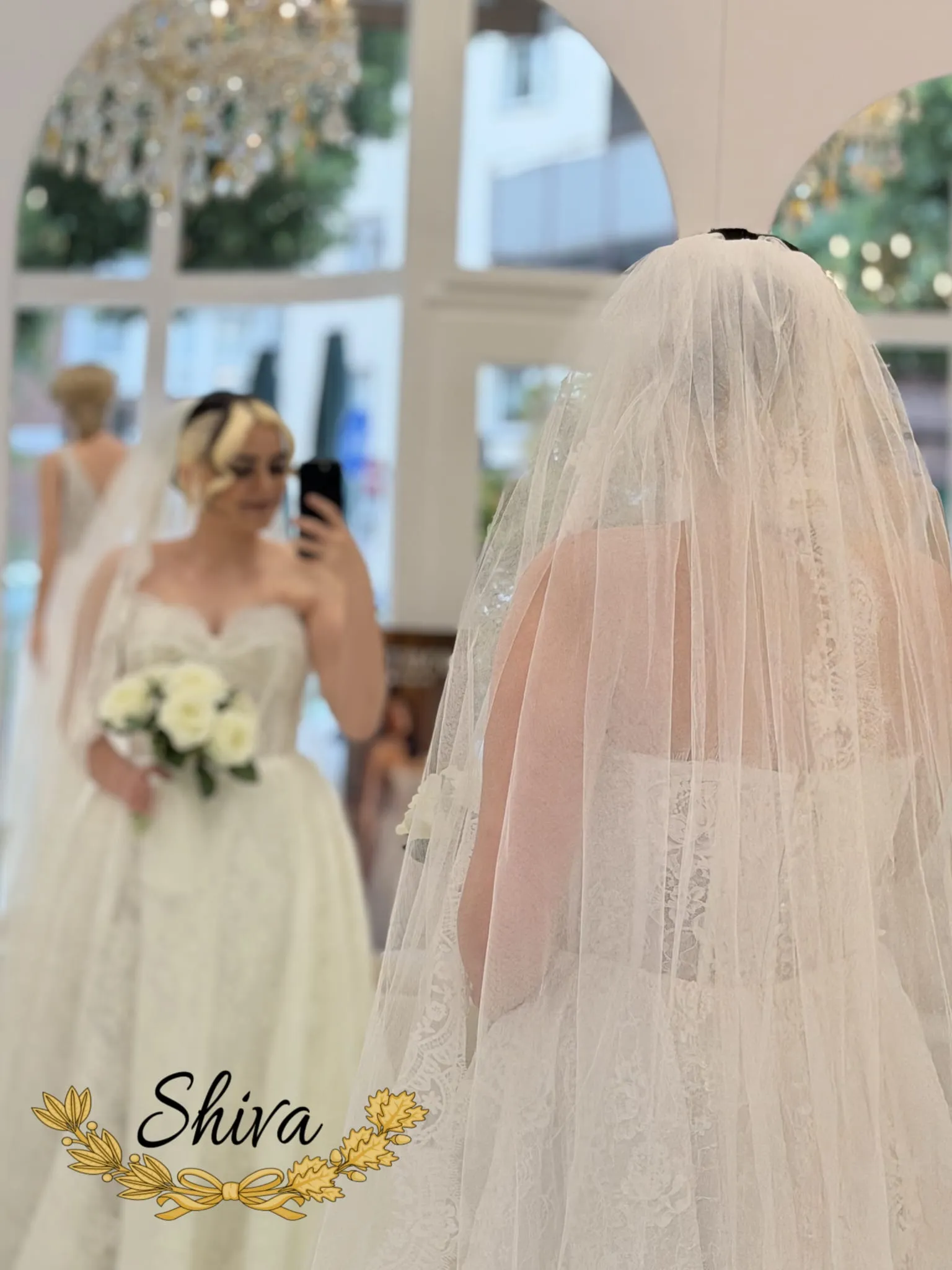 Eine Braut steht vor dem großen Wandspiegel in der Shiva Beauty Lounge in Mannheim vor ihrer Hochzeit.